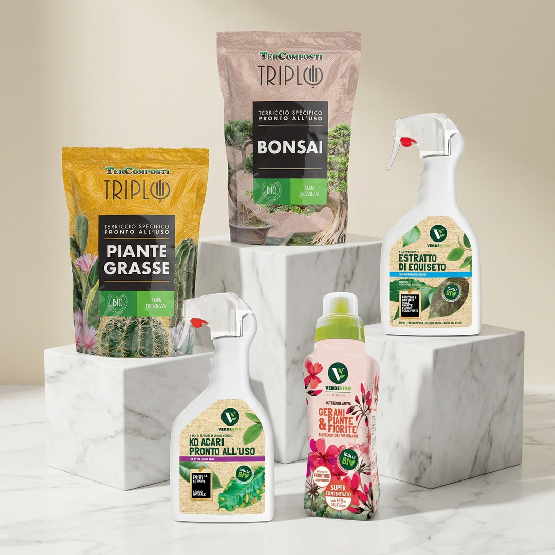 Concime granulare di colore celeste bluastro , tenuto in un palmo di mano in mezzo a delle piante