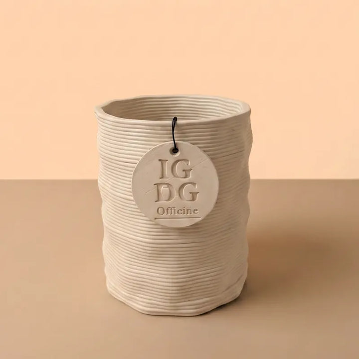 Vaso Andromeda in argilla con superficie rigata e forma cilindrica su sfondo beige per piante da interno