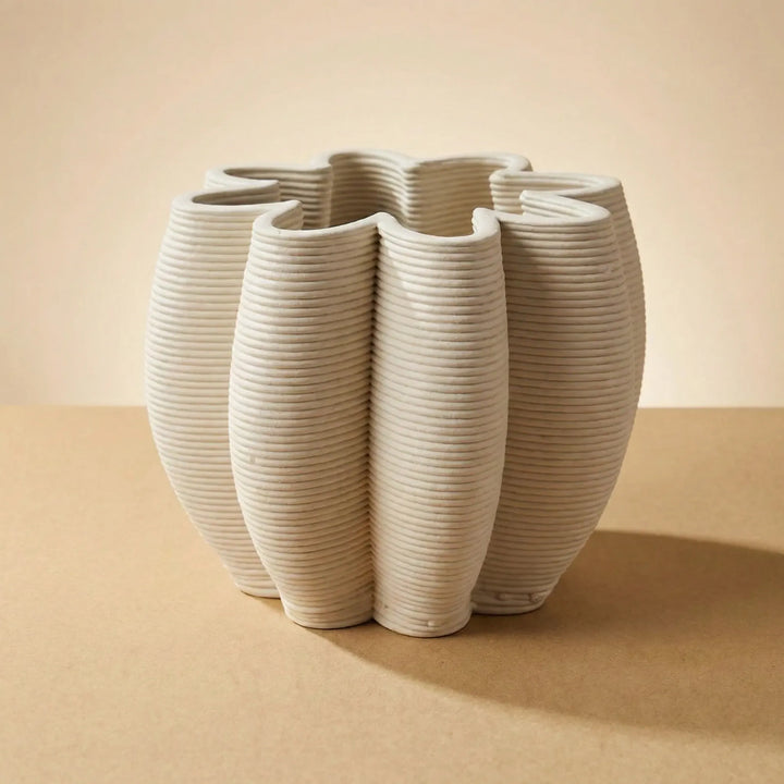 Vaso Gea in ceramica artigianale beige con superficie scanalata e forma decorativa su sfondo neutro