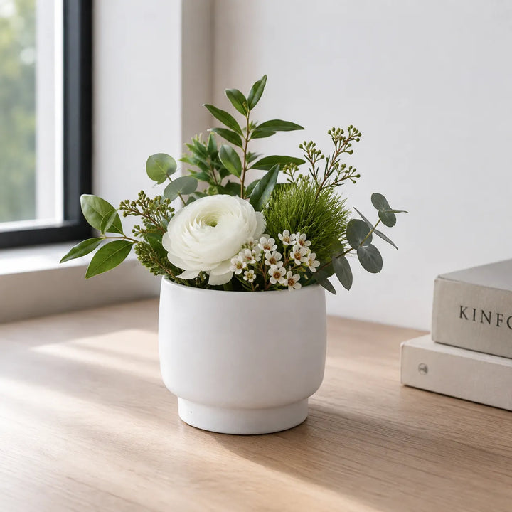 Vaso Sweet bianco con composizione di fiore bianco, eucalipto e fogliame verde, ideale per arredare ambienti luminosi in stile moderno e naturale.