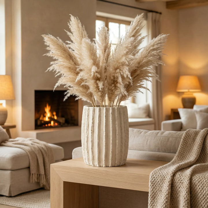 Vaso Dafne L con pampas decorativa su tavolino in soggiorno con camino acceso